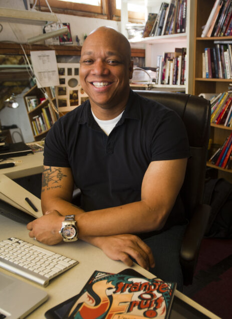Joel Christian Gill (CFA'04) is the author and illustrator of a comic book called Strange Fruit which tells the stories of little-known African Americans who made an impact on history. He's smiling on a sunny afternoon in his office space. Photo by Cydney Scott for Boston University.