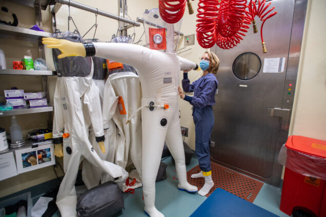 A scientist named Ellen Suder preps her suit before working in the high containment lab, BSL-4, at the NEIDL. Photo by Cydney Scott for Boston University Photography.