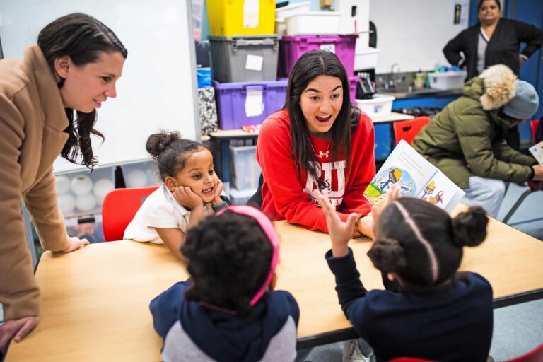 Basketball player, Annabelle Larnard (Questrom 23) reads to students at Hurley School. Photo by Jackie Ricciardi for Boston University.