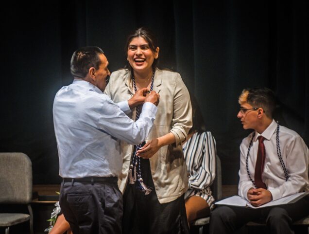 Allyson Imbacuan (CAS 23) receives a pin during the Newbury Center First Generation Pinning Ceremony and Reception at the Tsai Auditorium on May 19, 2023. She has an elated and proud look in the midst of the auditorium spotlighting.