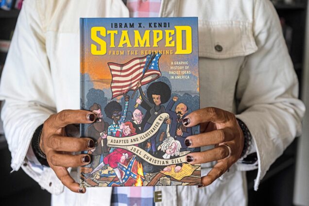 Joel Christian Gill, Associate Professor of Art; Chair, Department of Visual Narrative at CFA holds up a copy of his graphic novel "STAMPED" adapted from Dr. Ibram X. Kendi's.. Author of STAMED graphic novel adapted from Dr Ibram X Kendi’s book. Photo by Cydney Scott for Boston University Photography.