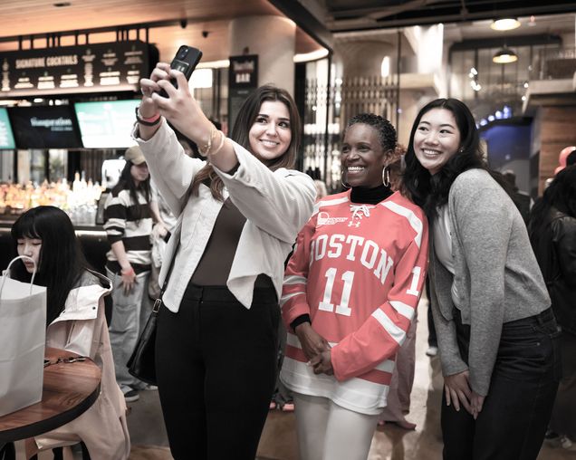 President Melissa Gilliam stopping for a selfie with two female students at Time Out Market