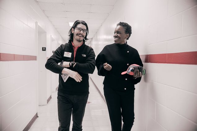 President Melissa Gilliam walking down a hallway with a man during a tour of athletic training facilities