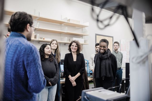 President Melissa Gilliam touring a lab at the Photonics Center with Associate Professor Rabia Yazicigil and a small group of students