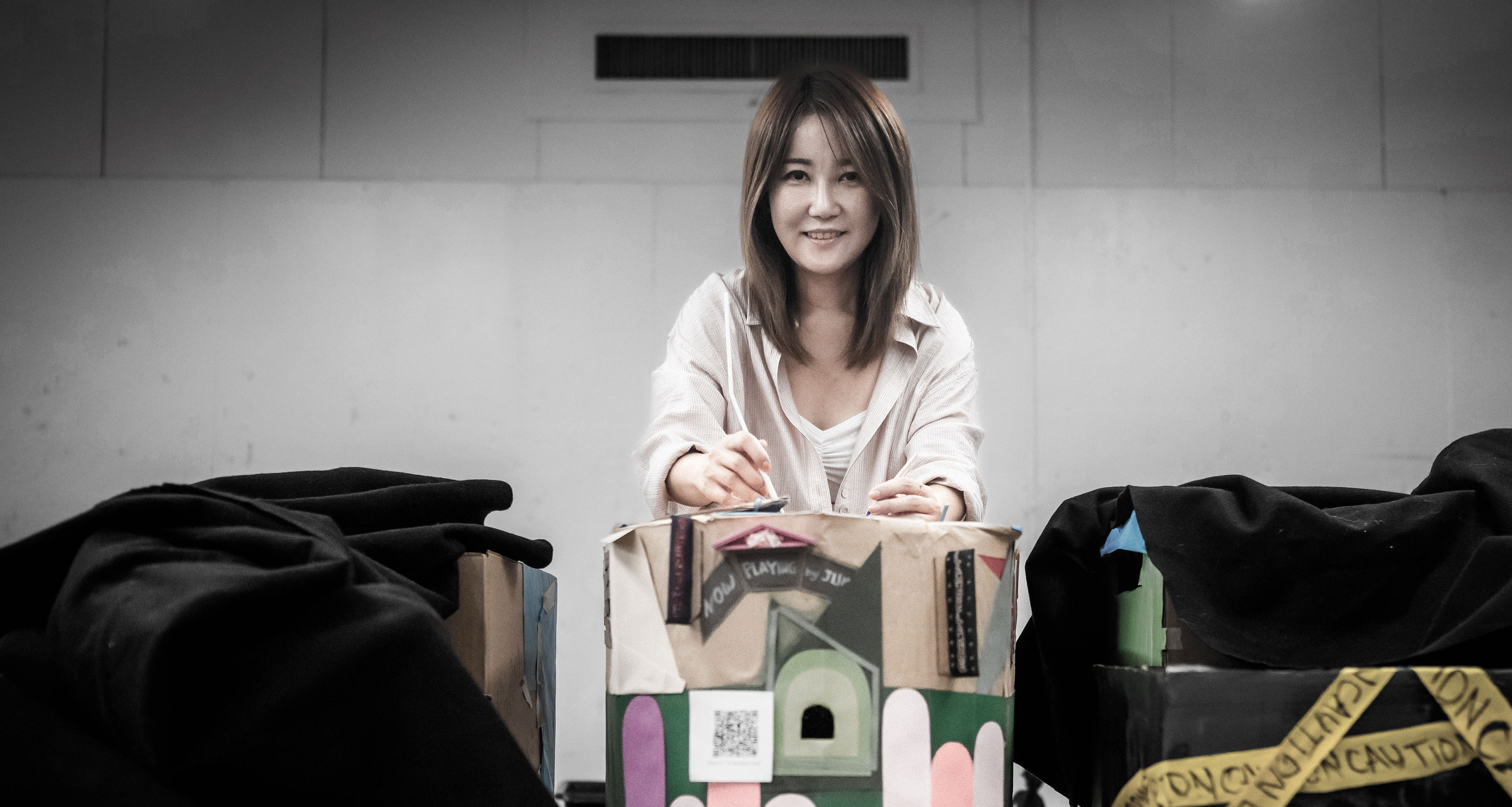 Ji Eun Lim standing in front of art projects she is working on